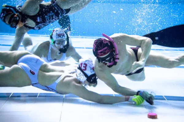 Underwater hockey players competing at the bottom of the pool